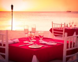 Table on beach set for romantic sunset dinner